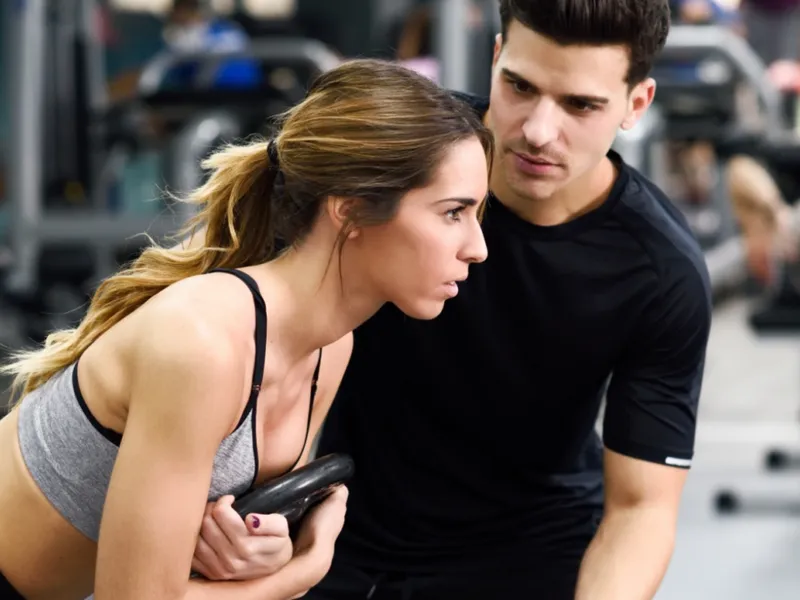 Personal trainer coaching a gym member